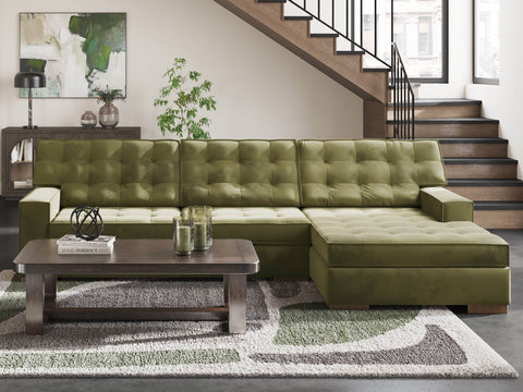 Caspian-Town olive green sectional with a tufted back and a corner chaise beside a staircase, with a dark wood coffee table and a patterned rug